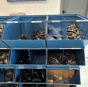 hinges, elbows, and various metal accessories in bins